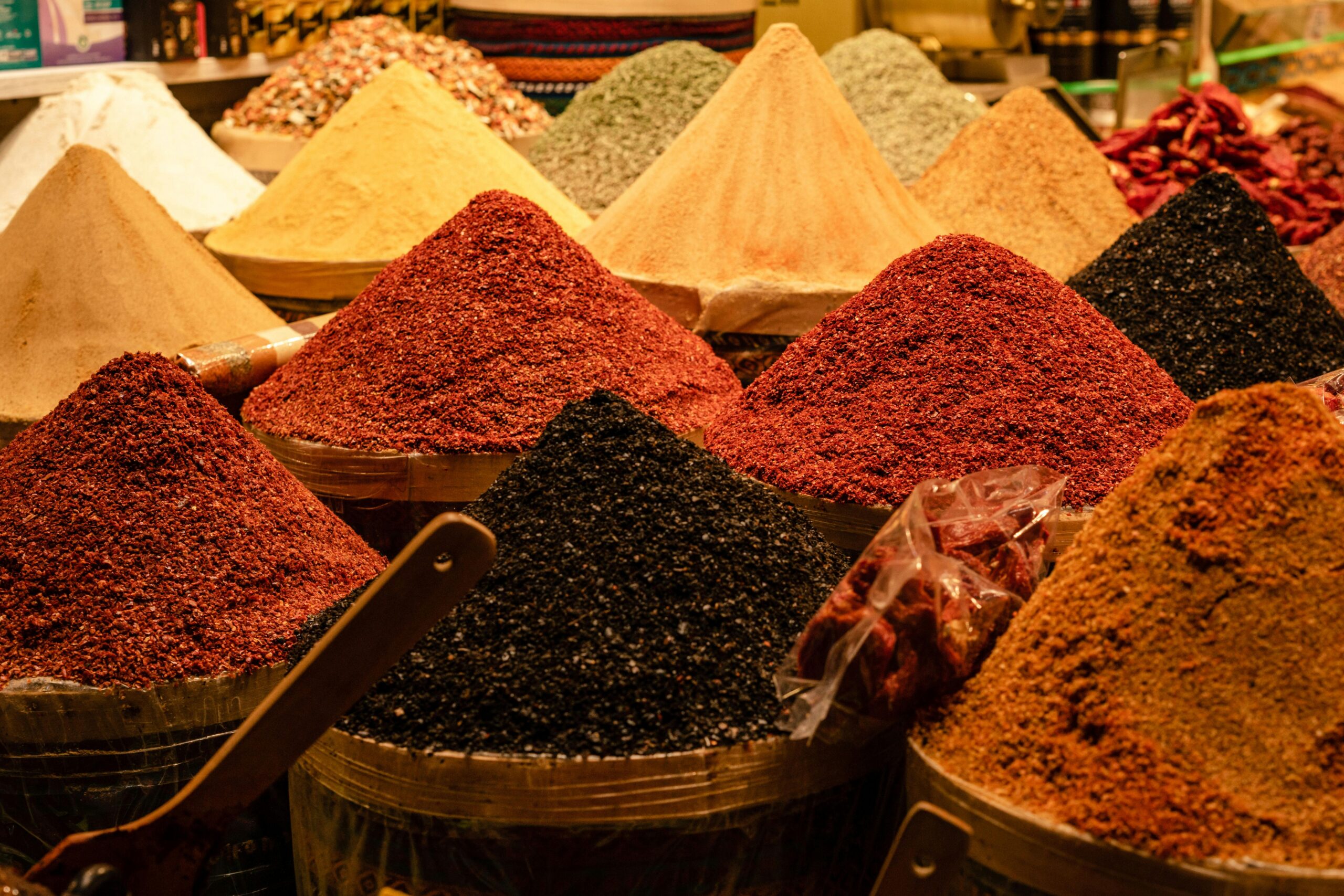 Vibrant array of spices displayed in pyramids at an open market. Perfect for food themes.